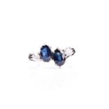 A sapphire and diamond four stone ring, the oval cut sapphires in six claw mounts each with an off-