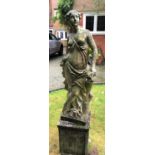 A reconstituted stone garden statue emblematic of Spring, modelled as a classical semi draped muse