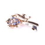 A yellow metal, diamond, and sapphire floral spray brooch, set with round cut stones, unmarked, 6 cm