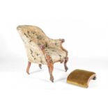 A Victorian armchair and footstool, mid 19th century, the chair with carved walnut show frame,