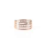 A four row diamond ring, the baguette and trapeze cut diamonds channel set within a wide band,