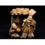 A Japanese ivory okimono, Meiji period, carved as a bearded figure holding a fan and carrying a