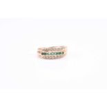 An 18ct yellow gold, diamond, and emerald band ring enclosed set to centre with round-cut