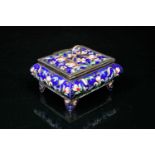 A Russian silver and enamel trinket box, with loop handle, decorated with enamel flowers against a