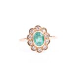 An 18ct yellow gold, diamond, and emerald cluster ring, set with a mixed oval-cut emerald,