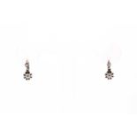 A pair of diamond drop earrings, the articulated mounts claw-set with a smaller and larger