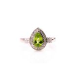 A 14ct white gold, diamond, and peridot ring, set with a pear-cut peridot of approximately 1.15