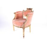 A French Empire period carved giltwood and upholstered boudoir chair, the backrest carved with a