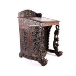 A 19th century Anglo-Indian rosewood Davenport, Bombay circa 1870/80, relief carved throughout