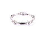 A diamond bangle, composed of five openwork round brilliant cut diamond clusters with double bar