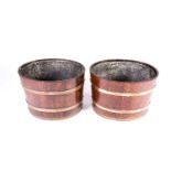 A pair of coopered oak coal receivers, early 20th century, each of oval form with copper bands,