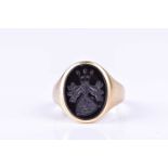 A gentleman's signet ring, set with an intaglio egraved crest to oval onyx plaque, within a tapering