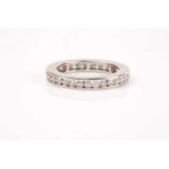 A diamond eternity ring, the white metal band channel-set with round brilliant-cut diamonds of