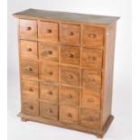 A teak apothecary type chest drawers, the top with applied moulded edge above twenty short drawers