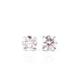 A pair of single stone diamond earrings, the round brilliant cut diamonds in simple four claw