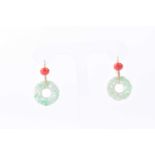A pair of carved jade and coral ear pendants, the foliate carved jade discs suspended from discs set