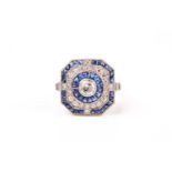 A diamond and sapphire target-style ring, in the Art Deco taste, centred with a round-cut diamond
