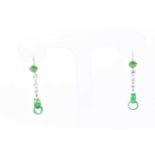 A pair of jade and diamond pendant earrings, a central circular jade cabochon suspending three