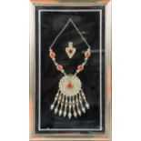 An Eastern white metal necklace, set with assorted hardstones, mounted and framed, the frame 69 cm