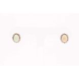 A pair of diamond and opal cluster earrings, set with oval cabochon opals within borders of round