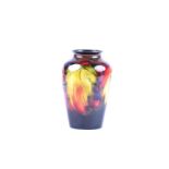A small Moorcroft vase in the Leaf & Berry pattern, of shouldered tapering form, painted and
