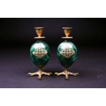 A pair of Russian silver gilt and malachite chamber sticks, the malachite body of egg form on silver