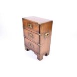 A small late 19th or early 20th century campaign style three-drawer chest, with brass mounts on