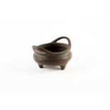 A small Chinese bronze censer, Qing, 19th century, of compressed form with two sprung handles, on