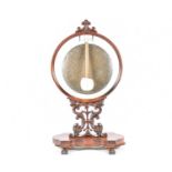 A Victorian carved mahogany dinner gong, circa 1870, with scroll terminal on a circular frame with