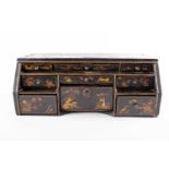 A 19th century lacquered table-top desk with chinoiserie decoration and nine tiered drawers, 17 cm x