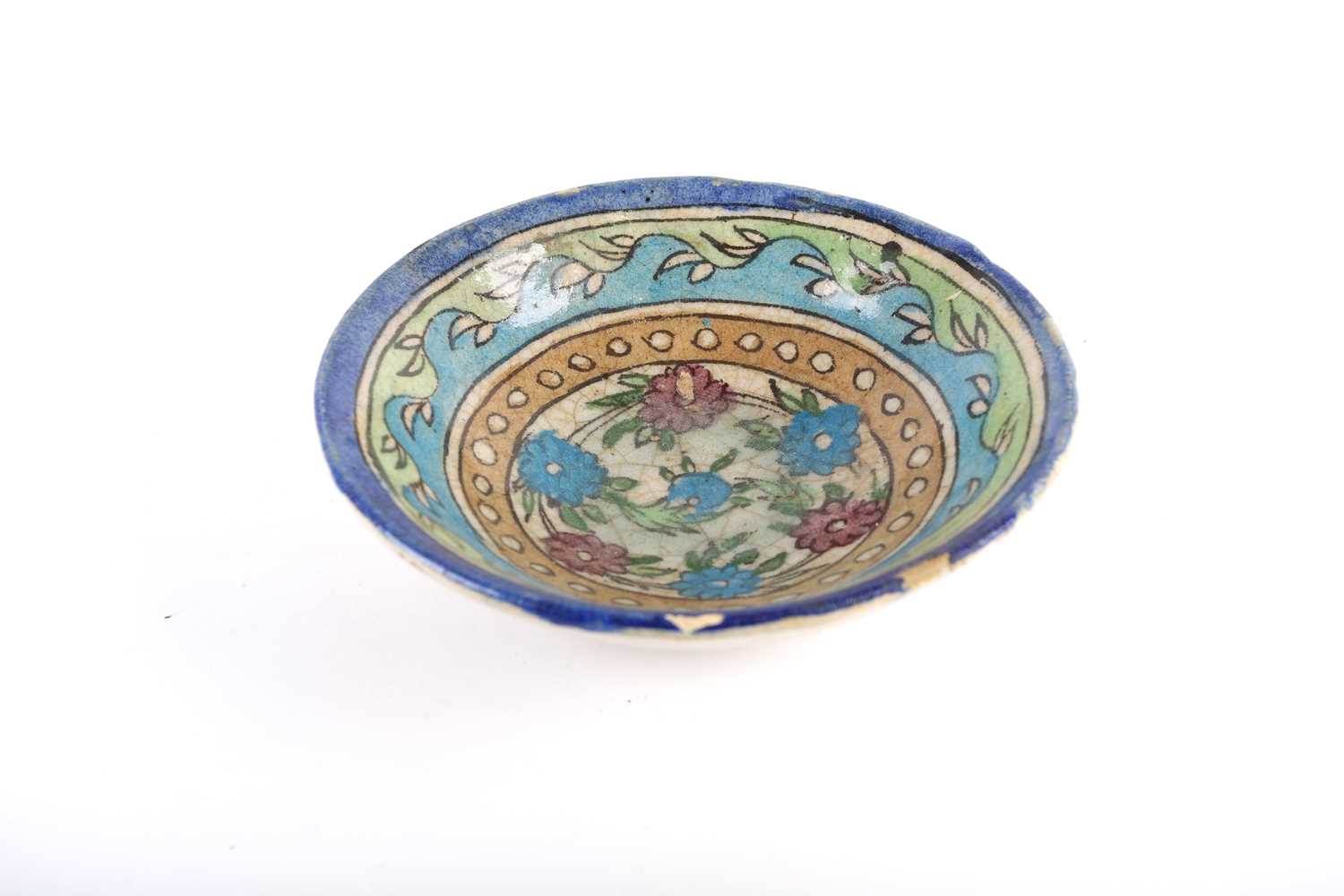 A Persian Isnik pottery bowl, Safavid/Qajar 18th century, the interior painted with flowers