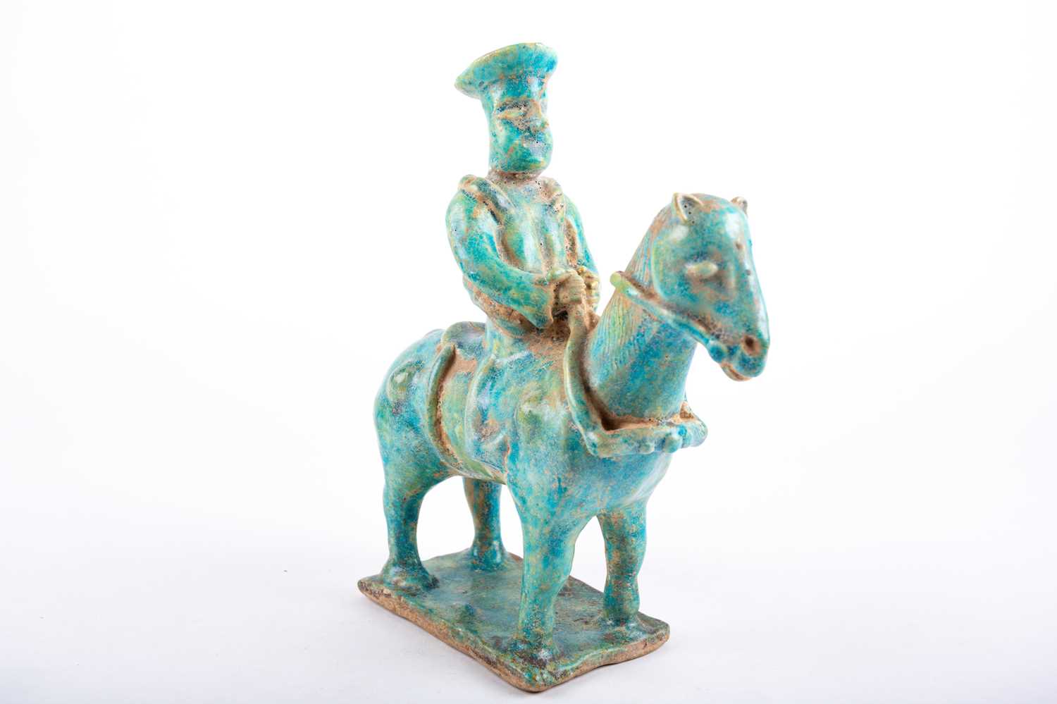 A Persian Kashan pottery equestrian figure, 13th century or later, the seated figure wearing a hat