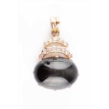 An unusual diamond and cats eye chrysoberyl pendant, mounted in rose metal (marked 14K, tests as