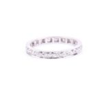 A diamond eternity band ring, the white metal shank inset with round Swiss-cut diamonds, unmarked (