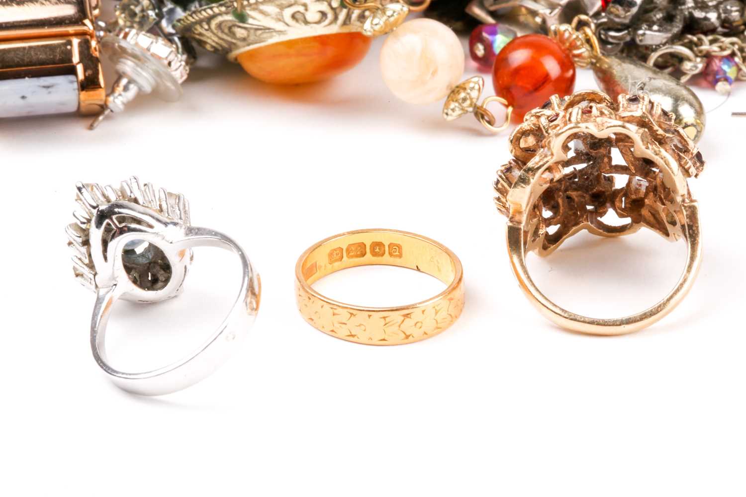 A small group of rings, comprising a 22ct gold wedding band, a 9ct gold cluster ring, and a white - Image 5 of 6