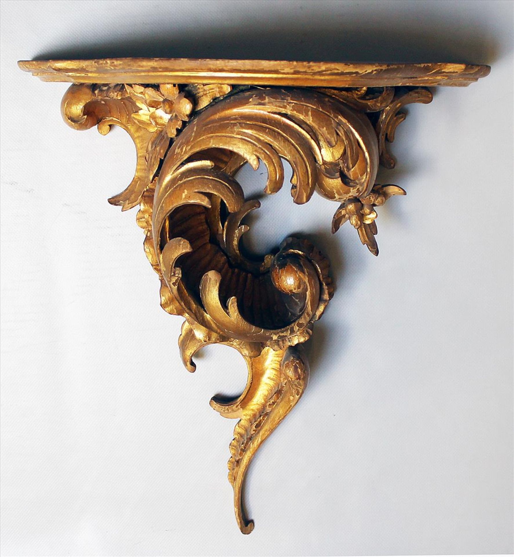 Konsole im Rokoko-Stil.Holz, geschnitzt und vergoldet. Best. Um 1900. 45x 41x 25 cm.