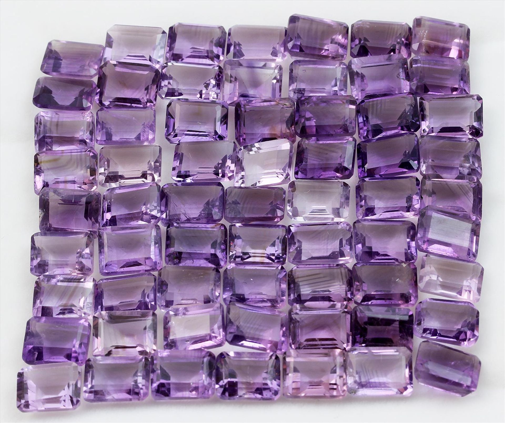 Lot aus 63 Amethysten, zus. ca. 146,85 ct.Je im Smaragdschliff in abweichenden Farbtönen.