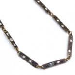 Lange Halskette.32 rechteckige Bronzeglieder, eingelegt mit weißen Emailblüten auf schwarzem -