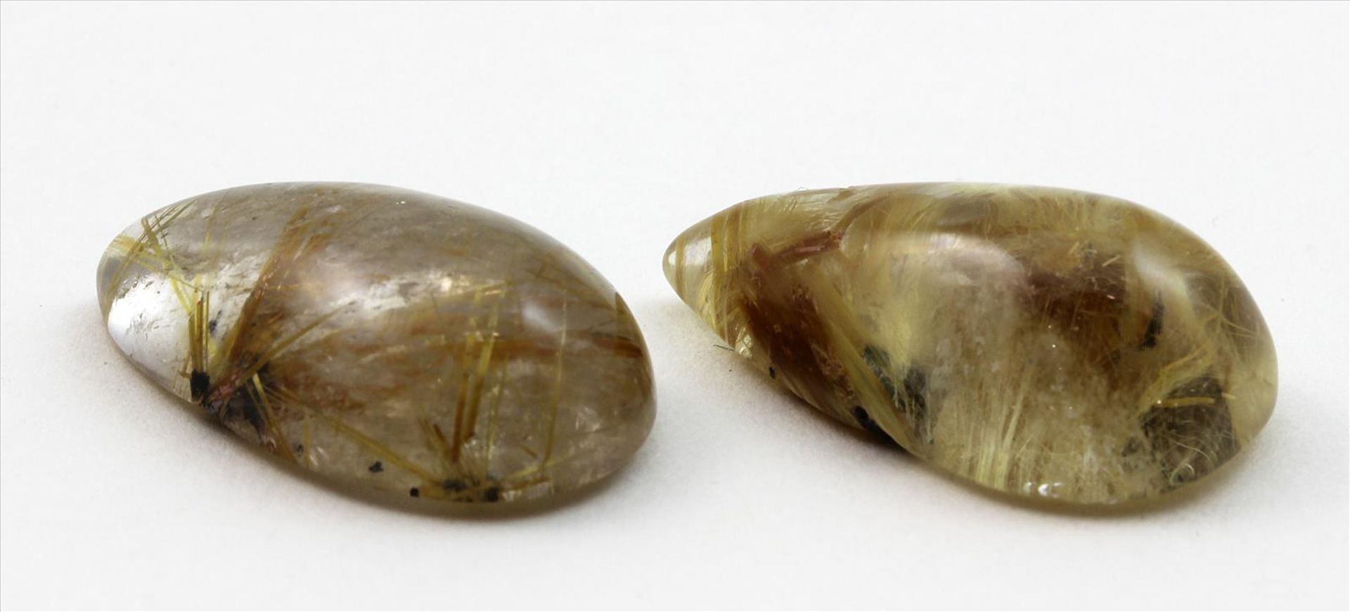 Zwei Bergkristalle mit Rutilnadeleinschlüssen, zus. 58,07 ct.Tropfenförmige Cabochons, L. ca. 2,8