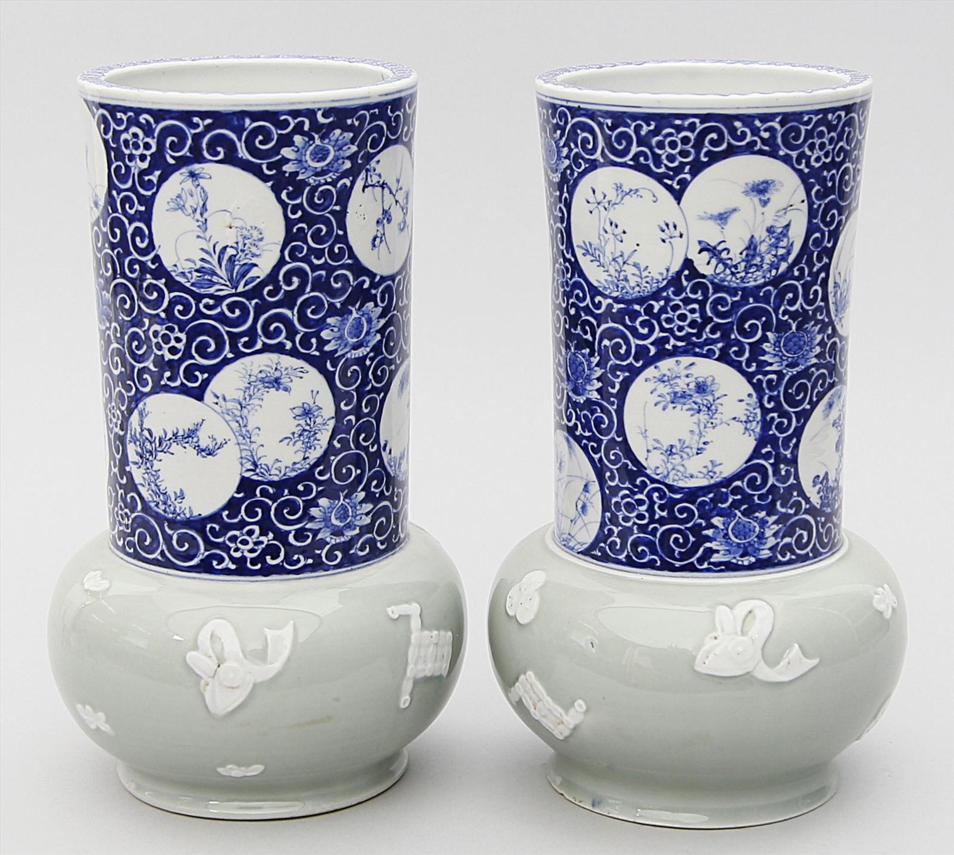 Paar Vasen.Porzellan. Gebauchte, seladonfarbene Laibung mit Reliefdekor, zylindrischer Hals mit