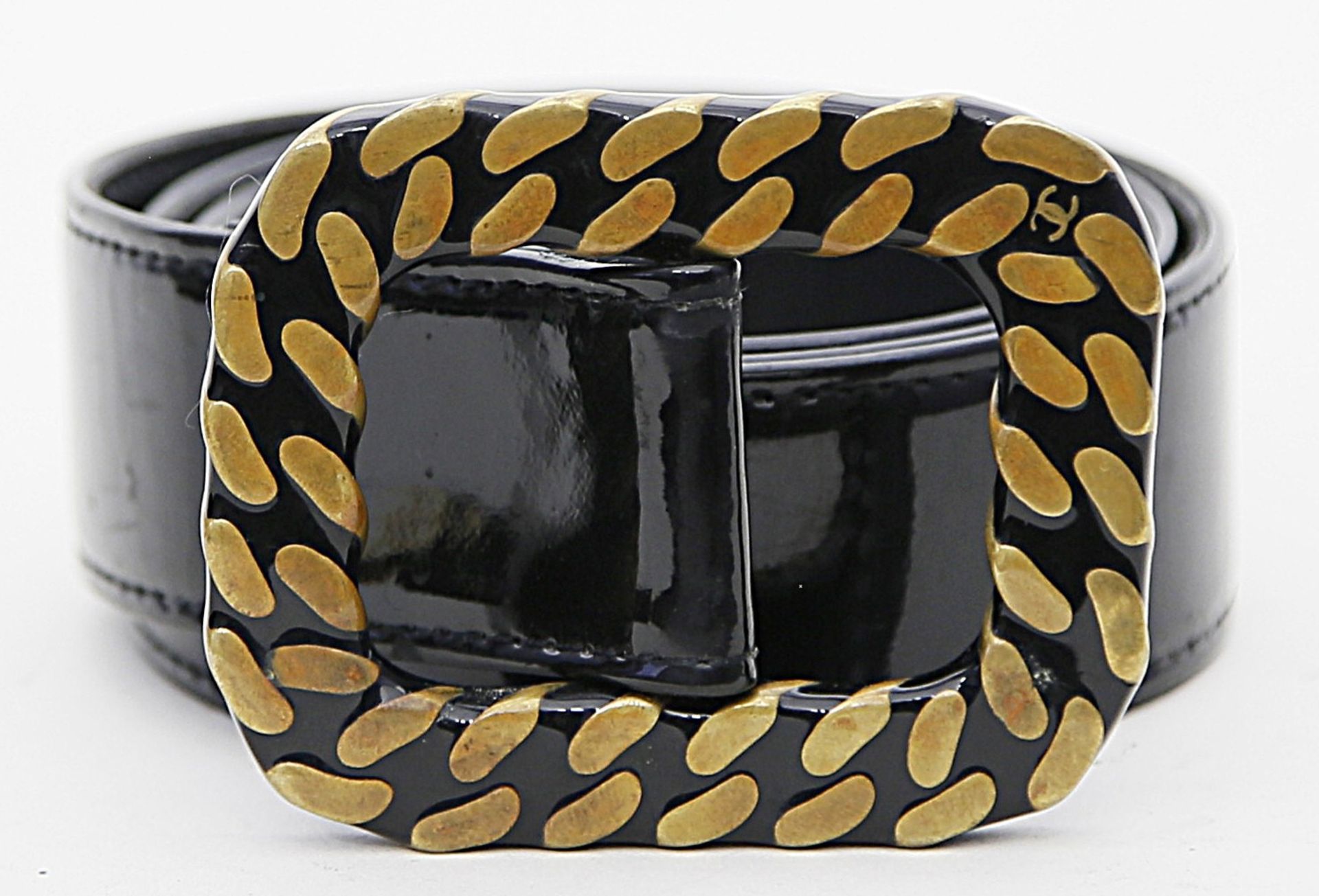 Gürtel, Chanel.Schwarzes Lackleder, Keramikschnalle mit goldenem Reliefdekor und CC-Logo.