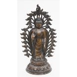 Stehender Buddha.Bronze mit brauner Patina. Der Buddha mit hoher Löckchenfrisur im Gestus der