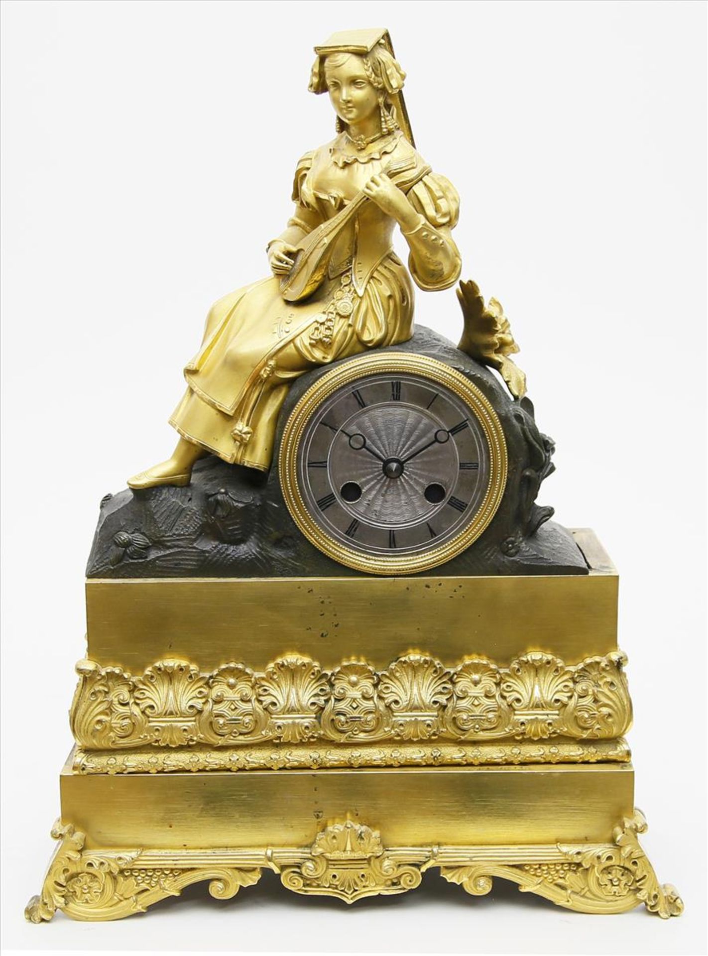 Empire-Uhrengehäuse.Vergoldete bzw. feuervergoldete Bronze, teils bronziert. Figürlicher Aufsatz
