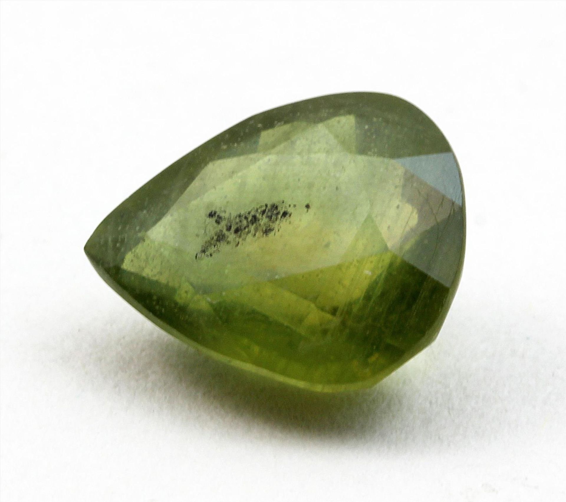 Grüner Saphir, ca. 6,86 ct.Birnkernförmig facettiert mit natürlichem Merkmal, wohl farbbehandelt.