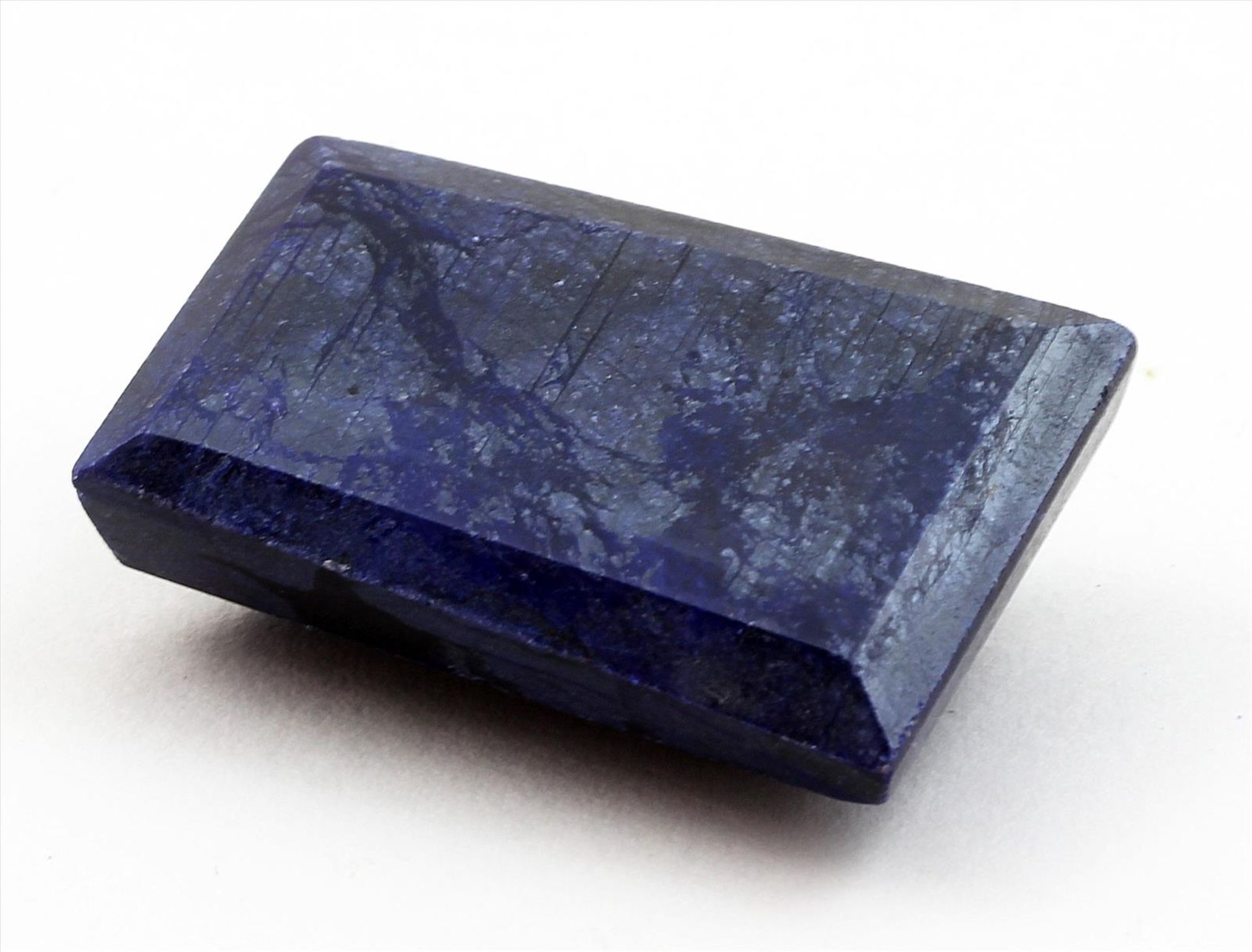 Großer, blauer Saphir, 144,35 ct.Trapezförmig facettiert. Opak, Kanten l. best. 38x 32x 12 mm.