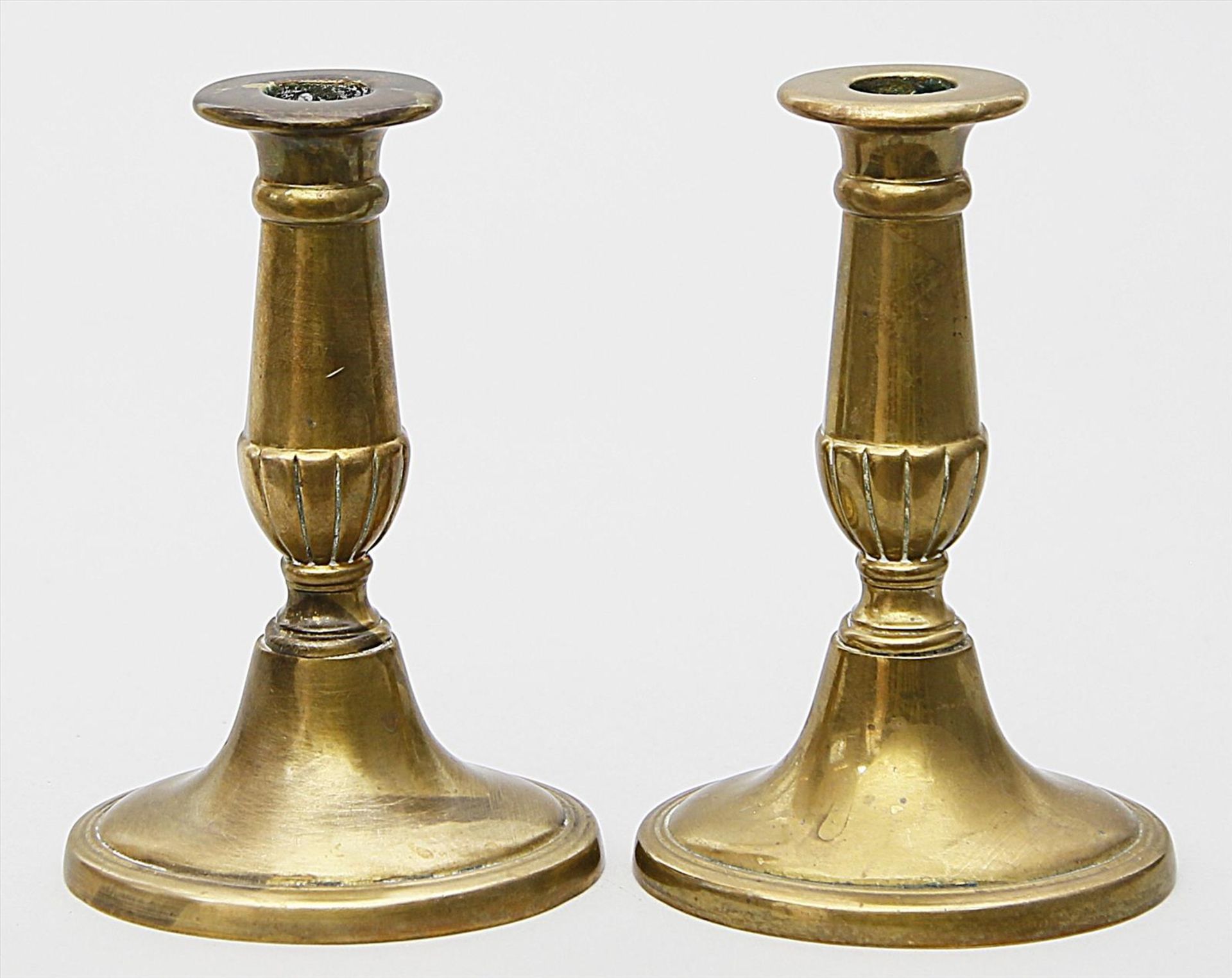 Paar Kerzenleuchter, je einflammig.Messing oder Bronze. Oval gebauchter, teils kannelierter Schaft