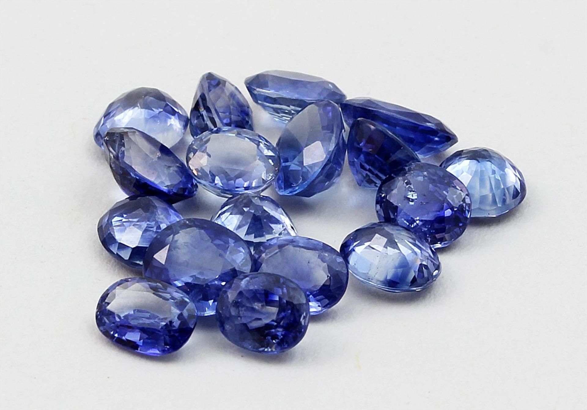 17 blaue Saphire, zus. 8,1 ct.Überwiegend oval facettiert in l. abweichender Größe und Farbe.