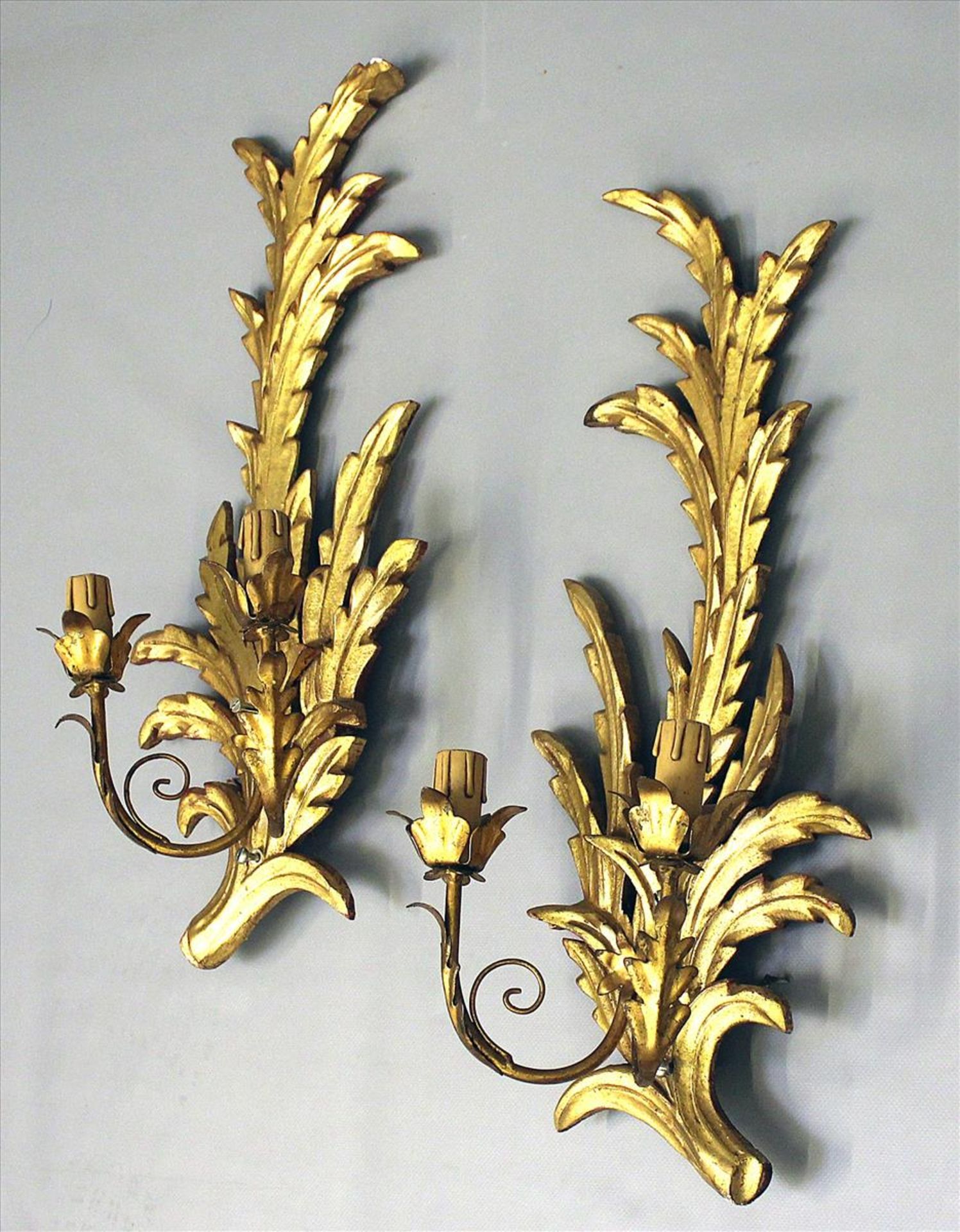 Paar Wandleuchten, je 2-flammig.Holz, in Form von Blattwerk geschnitzt und vergoldet (1x rep.).