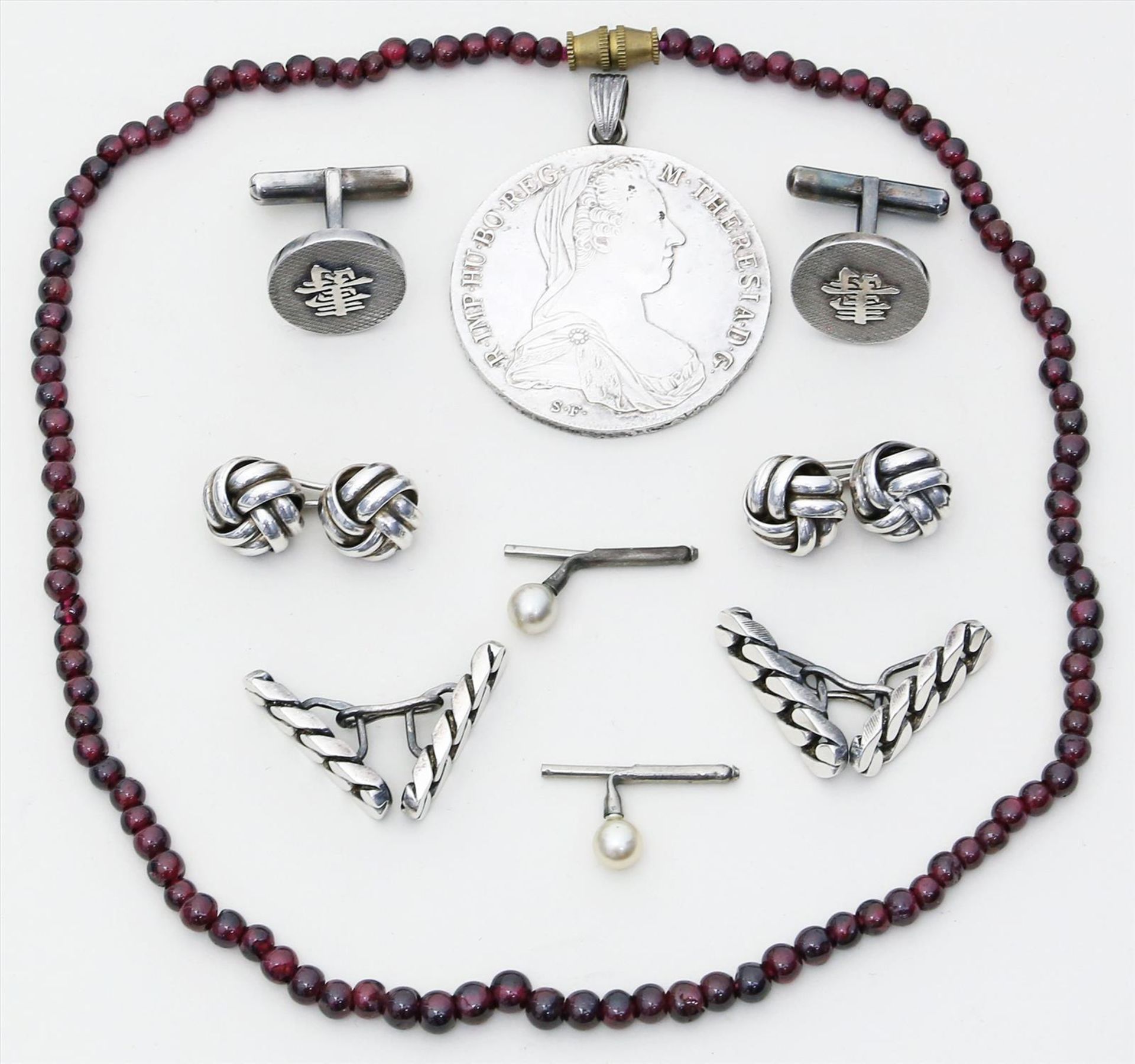 3 Paar Manschettenknöpfe.Silber. Beigegeben: Maria-Theresien-Taler mit Öse, Granatkette (L. 42 cm)