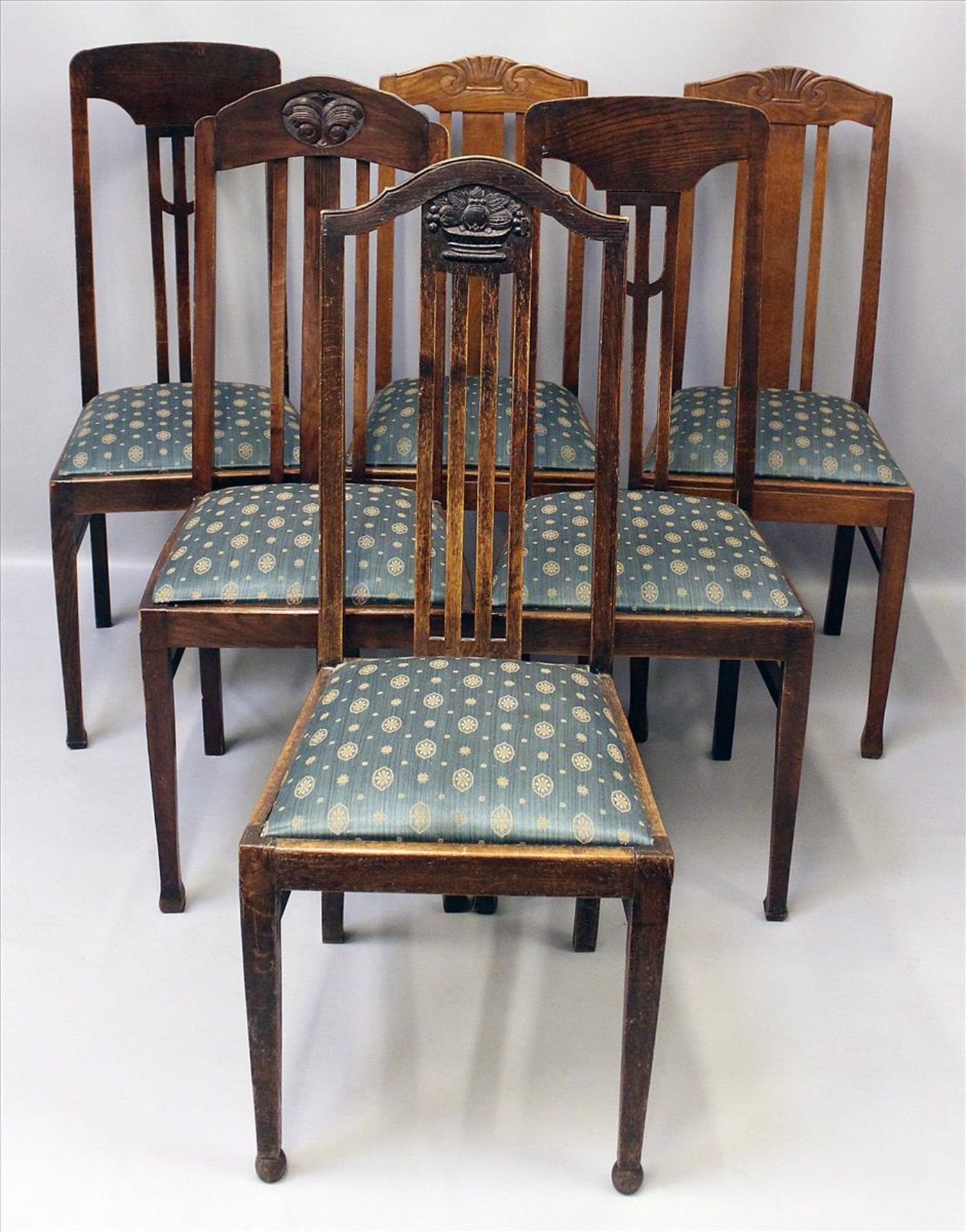 6 Stühle.Eiche. Pfostenbeine, Rückenlehnen teils mit geschnitzten Elementen. Sitz gepolstert. Um